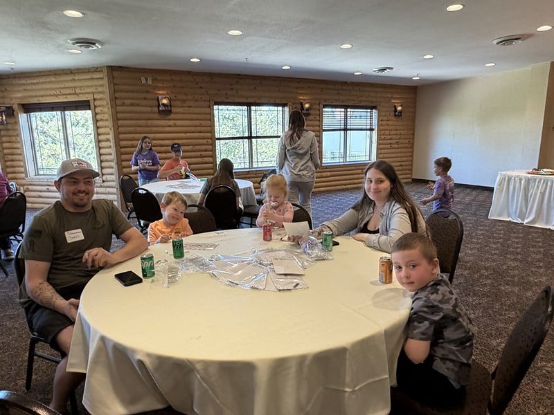 Attendees pose for a photo at the event while socializing at a table