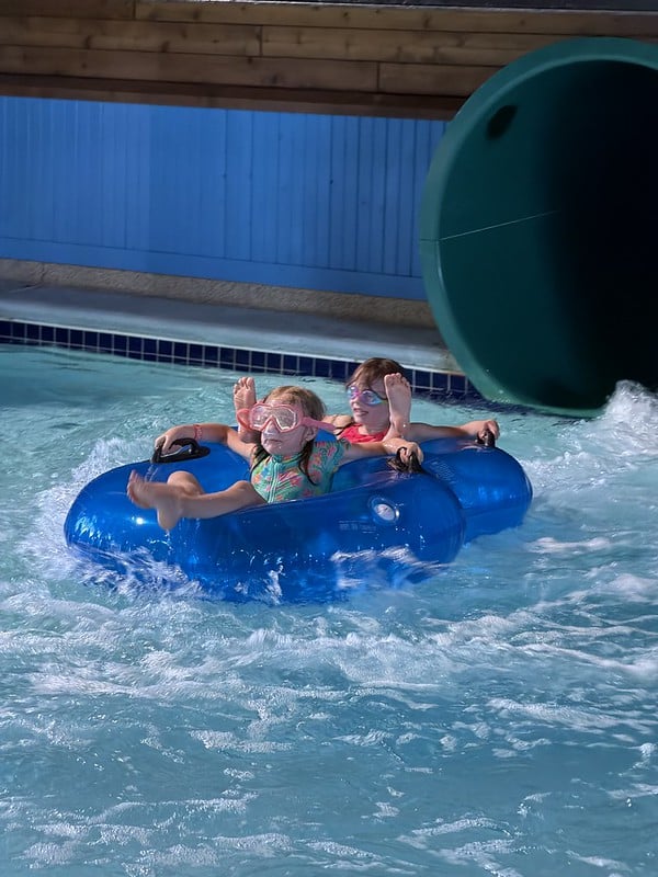 Attendees in a double inner tube going down the waterslide with goggles on
