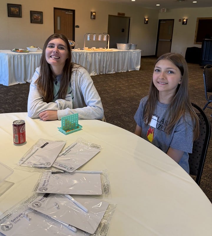 Attendees pose for a photo at the event while socializing at a table